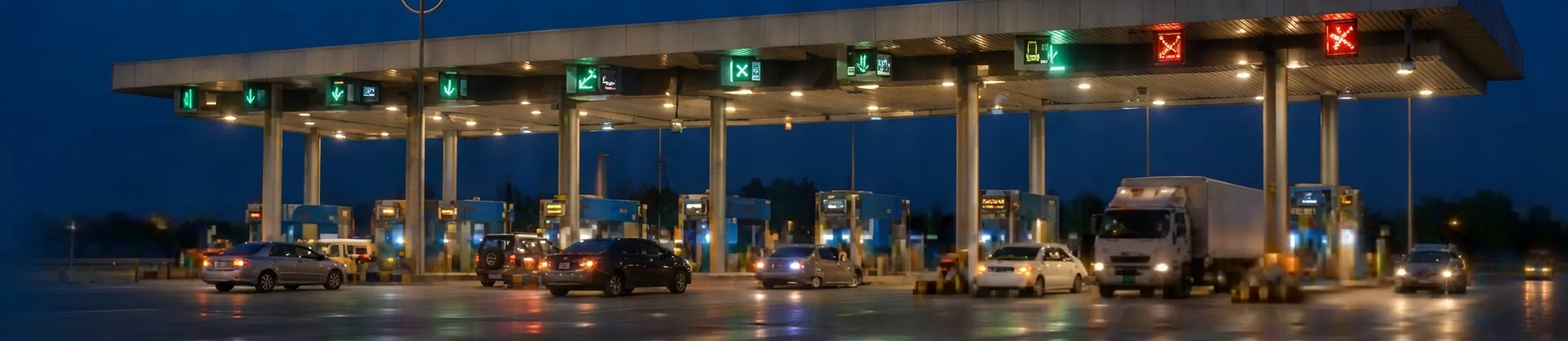 Toll plaza with multiple lanes illuminated at dusk